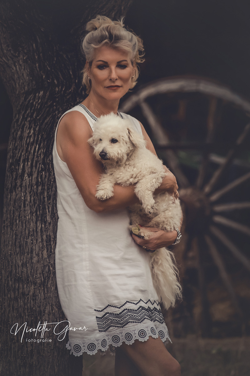 Frau mit weissem Hund auf dem Arm